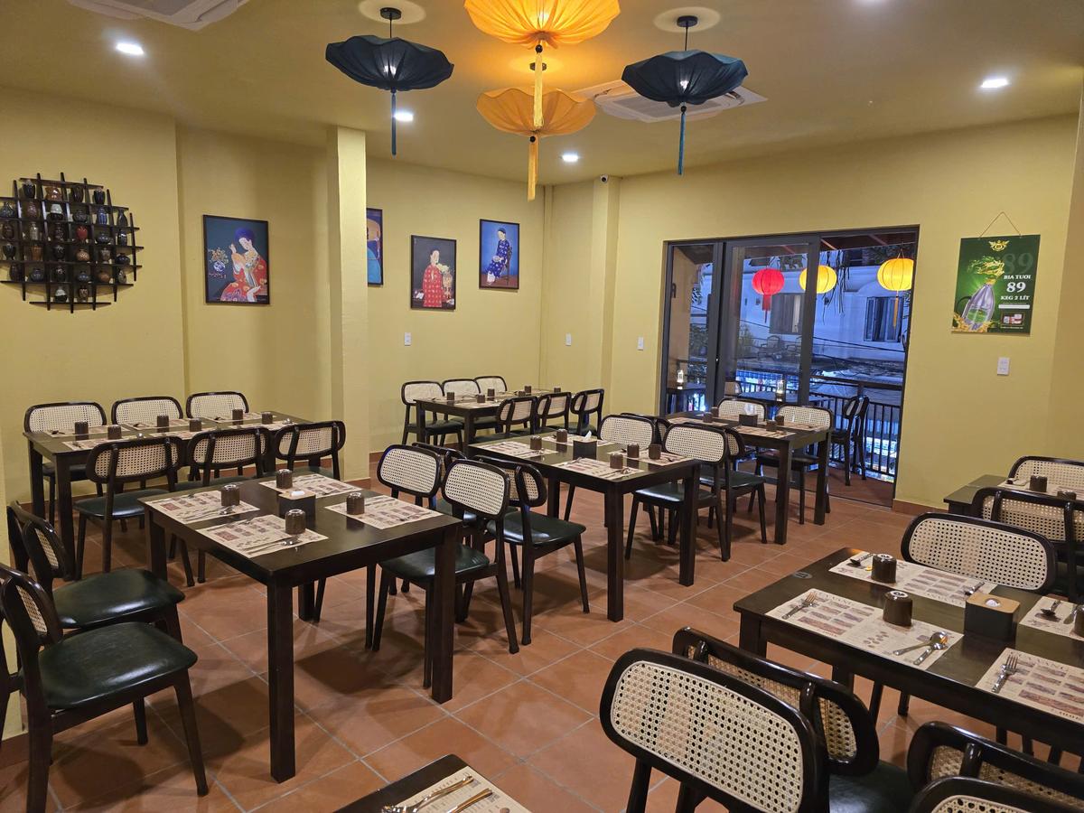 Second floor dining room at CUA VANG Seafood Hoi An — Vietnamese artwork and lantern decor